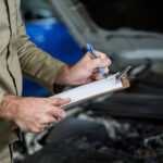 Driver checking tires for vehicle maintenance and road safety