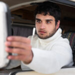 Commercial truck driver checking mirrors for blind spot awareness