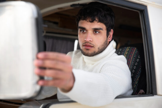 2149295086 Commercial truck driver checking mirrors for blind spot awareness