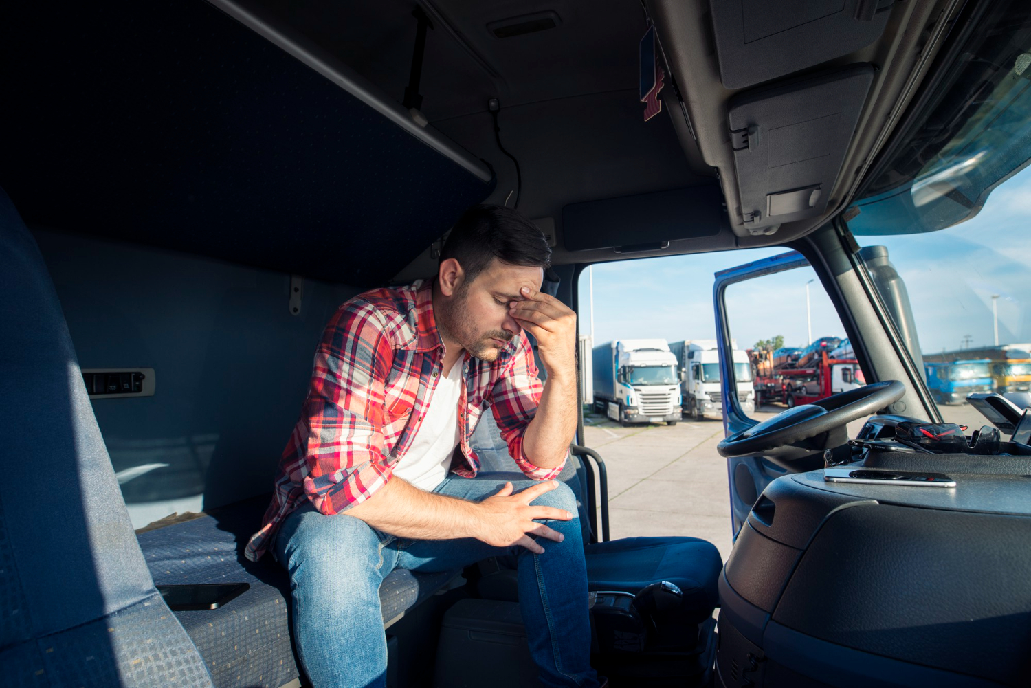 truck-driver-sitting-his-truck-cabin-feeling-worried-upset Commercial driver recognizing early signs of fatigue